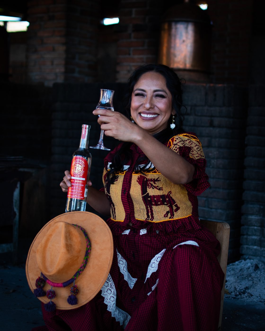 Chef Adhey brindando con mezcal en su cocina de Oaxaca